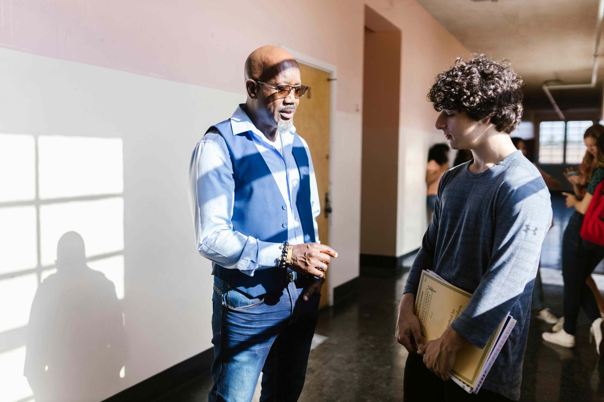 A Knowledge Road provider talking with a student in a school hallway